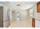 Open kitchen space with stainless steel refrigerator and tile flooring, providing a bright and airy atmosphere at 1200 25Th W Ave, Palmetto, FL 34221