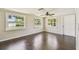 Bright living room with hardwood floors, two windows offering natural light, and a ceiling fan for comfort at 1200 25Th W Ave, Palmetto, FL 34221