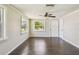 Bright living room with hardwood floors, two windows offering natural light, and a ceiling fan for comfort at 1200 25Th W Ave, Palmetto, FL 34221