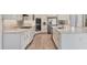 Spacious kitchen featuring white cabinetry, stainless appliances, large island, and hardwood floors, ideal for cooking and entertaining at 12005 Trails Reserve Ct, Sarasota, FL 34238