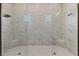 Contemporary walk-in shower with marble-style walls, a mosaic tiled floor, two windows, and built-in seating at 12005 Trails Reserve Ct, Sarasota, FL 34238