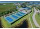 Aerial view showcases the community pool, tennis courts, and beautiful landscaping in this waterfront neighborhood at 1312 Perico Point Cir, Bradenton, FL 34209
