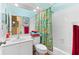 Bathroom with floral shower curtain, white tiled walls and ceiling and white vanity with sink at 1312 Perico Point Cir, Bradenton, FL 34209