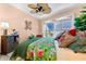 Bedroom with ceiling fan, tropical bedding, louvered shutters and plants at 1312 Perico Point Cir, Bradenton, FL 34209