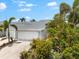 Exterior of home with 2-car garage and lush landscaping including many mature palms at 1312 Perico Point Cir, Bradenton, FL 34209