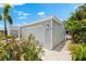 Charming single-story home with a light gray exterior, lush tropical landscaping, and a driveway to the left of the house at 1312 Perico Point Cir, Bradenton, FL 34209