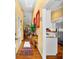 Inviting hallway with hardwood floors, yellow walls, and a view into the kitchen, seamlessly connecting living spaces at 1312 Perico Point Cir, Bradenton, FL 34209