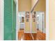 Hallway with wood floors, bright yellow walls, mirror closet doors and views to bathrooms with tile floors at 1312 Perico Point Cir, Bradenton, FL 34209