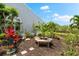 View of the landscaped garden with seating area and water view in the background at 1312 Perico Point Cir, Bradenton, FL 34209