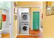 Hallway laundry closet with stackable washer and dryer, green louvered closet door and view to bathroom at 1312 Perico Point Cir, Bradenton, FL 34209