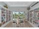Cozy library area with floor to ceiling bookshelves, a table and chairs, and an exit to the outside at 1312 Perico Point Cir, Bradenton, FL 34209