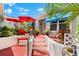 Inviting red patio with seating, colorful umbrellas, and potted plants, perfect for relaxing and outdoor enjoyment at 1312 Perico Point Cir, Bradenton, FL 34209