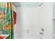 Shower and tub with white tile and floral shower curtain at 1312 Perico Point Cir, Bradenton, FL 34209