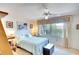 Bedroom with a bed, ceiling fan, natural light, and floral accents above the window at 1314 57Th W St # 1314, Bradenton, FL 34209