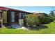 Home exterior featuring lush landscaping and green grass and access to the screened lanai at 1314 57Th W St # 1314, Bradenton, FL 34209
