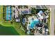Aerial view of a community pool, tennis courts, parking lot, and clubhouse surrounded by lush landscaping at 13708 Old Creek Ct, Parrish, FL 34219