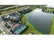 Scenic aerial view of a community pool, clubhouse, tennis courts, and lake, showcasing the beautiful landscape at 13708 Old Creek Ct, Parrish, FL 34219