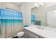 This bathroom includes a shower with a beach-themed curtain, a toilet, and a vanity at 13708 Old Creek Ct, Parrish, FL 34219