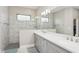 This primary bathroom boasts a double vanity, marble tiled shower, and a large mirror at 13708 Old Creek Ct, Parrish, FL 34219