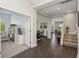 Inviting hallway with gleaming dark wood floors leading to various living spaces, promoting an open and airy feel at 13708 Old Creek Ct, Parrish, FL 34219