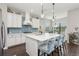 Bright kitchen features an island with barstool seating, stainless steel appliances and a blue tile backsplash at 13708 Old Creek Ct, Parrish, FL 34219