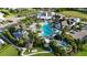 Aerial view of a lagoon style community pool surrounded by lush landscaping, cabanas and a spa at 13708 Old Creek Ct, Parrish, FL 34219
