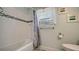 Bathroom boasts a shower/tub combo with decorative accent tiles, and lace curtains at 1461 Porpoise Rd, Venice, FL 34293