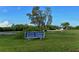 Sign for the South Venice Beach Ferry surrounded by green grass, shrubs and sparse trees at 1461 Porpoise Rd, Venice, FL 34293