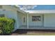 Close up view of home's entrance with storm door, tile porch and tidy landscaping at 1461 Porpoise Rd, Venice, FL 34293