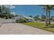 Exterior view of a light blue single-story home with a white metal roof and gravel driveway at 1461 Porpoise Rd, Venice, FL 34293