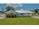 Charming single-story home featuring a well-manicured lawn, fresh landscaping, and a durable silver metal roof at 1461 Porpoise Rd, Venice, FL 34293
