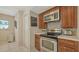 Kitchen showcases stainless steel appliances including microwave and range, mosaic backsplash and wood cabinetry at 1461 Porpoise Rd, Venice, FL 34293
