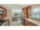 Spacious kitchen featuring wooden cabinets, stainless steel refrigerator, and a sink with natural light at 1461 Porpoise Rd, Venice, FL 34293