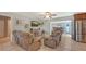 Open-concept living room featuring tile flooring, comfortable reclining sofas, and access to the kitchen at 1461 Porpoise Rd, Venice, FL 34293