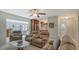 Open-concept living room featuring tile flooring, comfortable reclining sofas, and access to the kitchen at 1461 Porpoise Rd, Venice, FL 34293