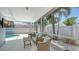 Inviting covered patio with stylish wicker furniture, providing a perfect spot for relaxation by the pool at 1461 Porpoise Rd, Venice, FL 34293