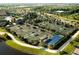 Aerial view of community with tennis courts, pool and clubhouse surrounded by lush landscape and homes at 16904 Vardon Ter # 208, Lakewood Ranch, FL 34211