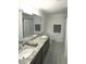 Clean bathroom featuring a double sink vanity with granite countertop and modern fixtures at 16904 Vardon Ter # 208, Lakewood Ranch, FL 34211