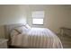 Cozy bedroom with a large window for natural light and a comfortable bed with striped linens at 16904 Vardon Ter # 208, Lakewood Ranch, FL 34211
