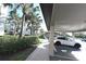 Carport with car parked, surrounded by lush greenery and palm trees at 16904 Vardon Ter # 208, Lakewood Ranch, FL 34211