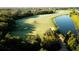 Scenic golf course view featuring manicured greens, lush trees, sand traps, and a tranquil lake at 16904 Vardon Ter # 208, Lakewood Ranch, FL 34211