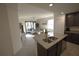 Modern kitchen island overlooking the spacious living room and balcony, featuring granite counters at 16904 Vardon Ter # 208, Lakewood Ranch, FL 34211