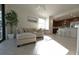 Open-concept living area with modern furnishings, a partial view of the kitchen, and bright, neutral colors at 16904 Vardon Ter # 208, Lakewood Ranch, FL 34211