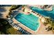 Resort style pool with rock features and ample seating surrounded by lush landscaping and well manicured lawns at 16904 Vardon Ter # 208, Lakewood Ranch, FL 34211