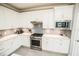 Bright kitchen featuring stainless steel appliances, white cabinets, and gray backsplash at 18008 Waterville Pl, Bradenton, FL 34202