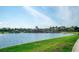 Scenic view of a lake with a lakeside clubhouse and lush green landscaping on a sunny day at 18008 Waterville Pl, Bradenton, FL 34202