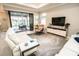 Bright living room with modern furniture, sliding glass doors, and views of the outdoor pool area at 18008 Waterville Pl, Bradenton, FL 34202