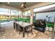 Covered patio with dining set overlooks the pool and pond, ideal for outdoor entertaining at 18008 Waterville Pl, Bradenton, FL 34202