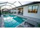 A screened in lanai featuring a beautiful pool with brick pavers and view of outdoor seating at 18008 Waterville Pl, Bradenton, FL 34202