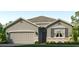 Charming single-story home with stone accents, a two-car garage, and a well-manicured lawn at 18212 Wheathouse Pl, Lakewood Ranch, FL 34211